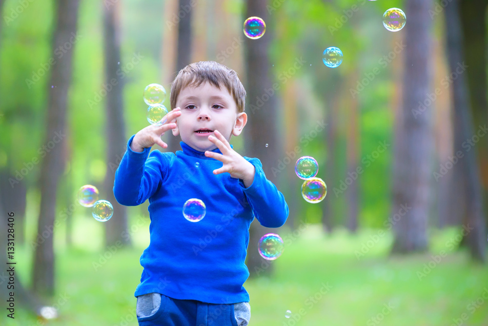 Little boy with soap bubbles in summer park. Little boy with soap bubbles in summer park.