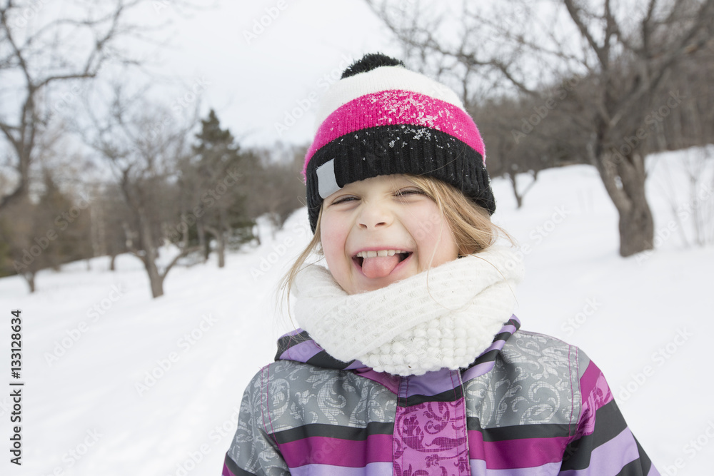 Little girl in winter pink hat in snow forest. Little girl in winter pink hat in snow forest.