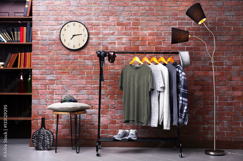 Casual stylish shirts on hanger stand in room - obrazy, fototapety, plakaty 
