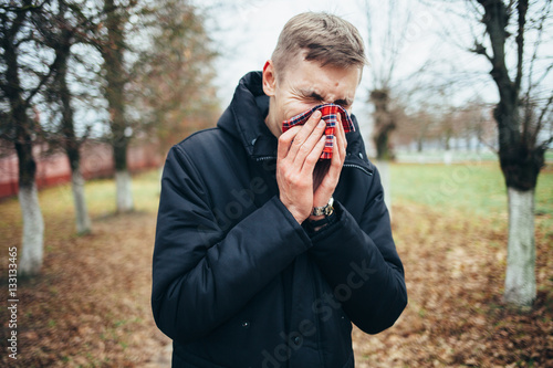 Quadro em tela Sick man blowing his nose into a handkerchief