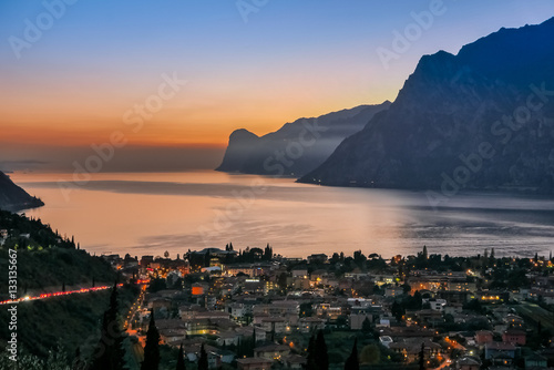 Beautiful night panorama of town lake and mountains