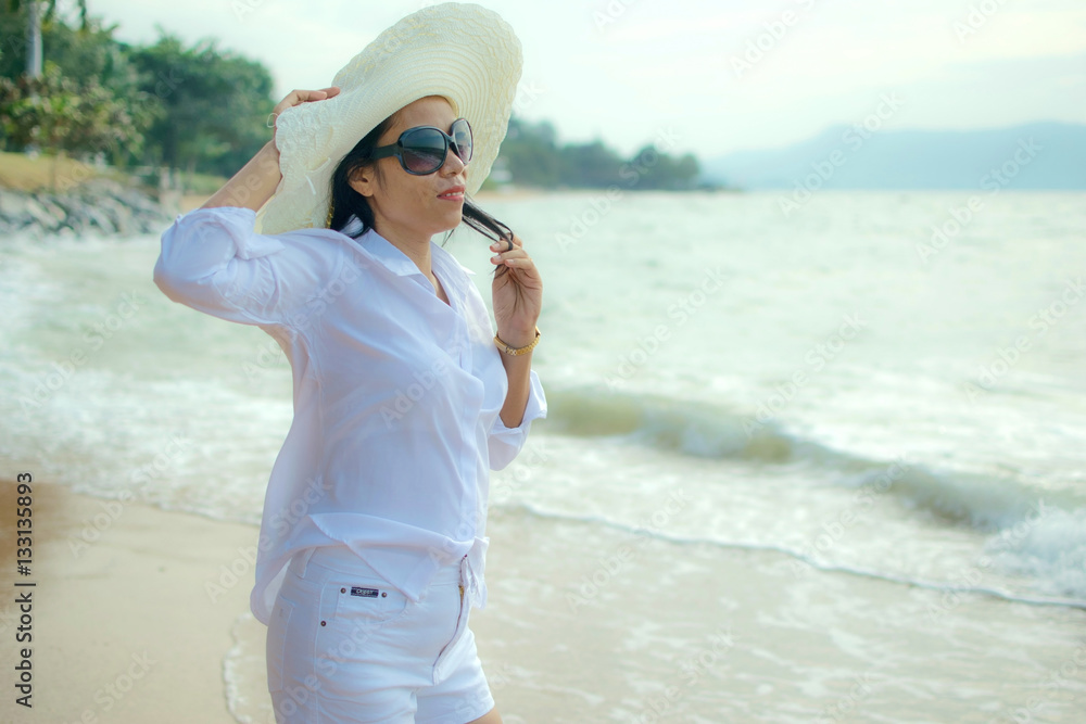 Sexy woman with white shirt and hat on the beach - glare effect