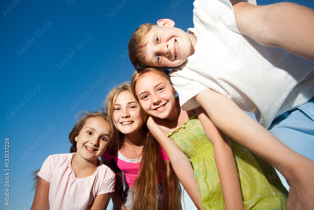 four happy beautiful children looking at camera from top in the sunny summer day and blue sky. looking at camera with funny face and toothy smile. view from below.
four happy beautiful children looking at camera from top in the sunny summer day and blue sky. looking at camera with funny face and toothy smile. view from below.