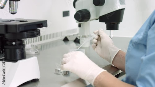 Scientist check sample in laboratory, Embryologist drop sperm specimen with disposable wholesale pipette in counting chamber and look on it through microscope.