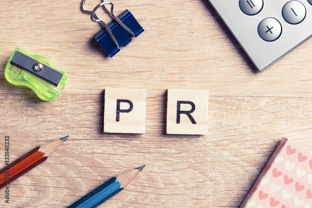PR abbreviation on table spelled with education game elements PR abbreviation on table spelled with education game elements