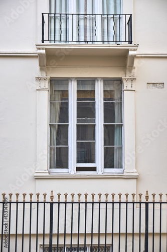 Photography Window section with three narrow hung frames in building facade with a balcony j