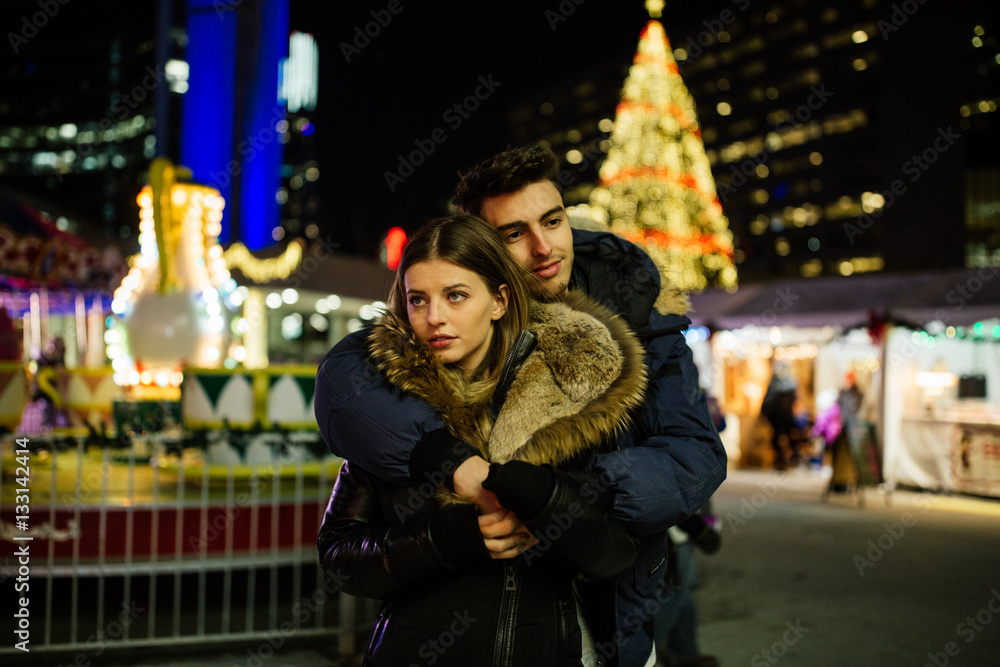 Boyfriend hugs girlfriend in winter wonderland Boyfriend hugs girlfriend in winter wonderland