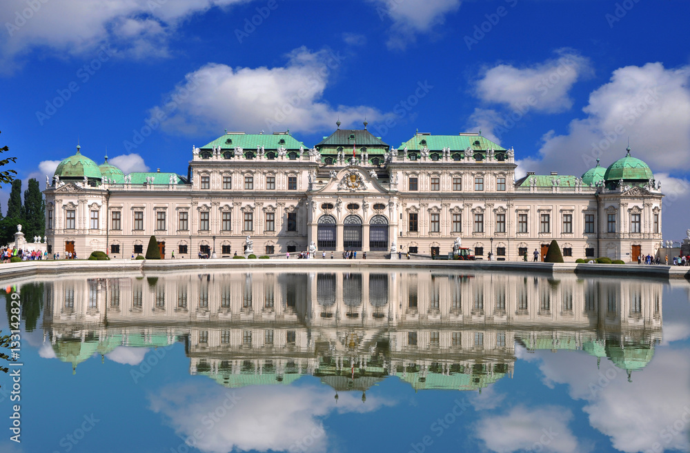View of famous Belvedere palace with a reflection in pool and blue sky, in Vienna, Austria