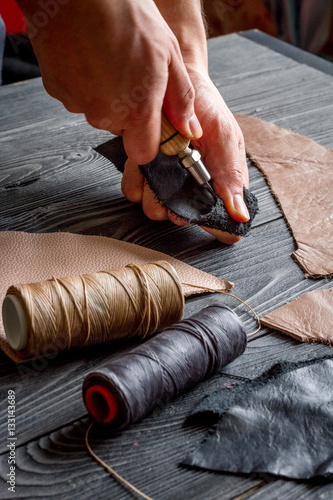 work in leather shop on dark wooden background close up