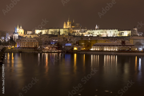 Night snowy Prague Lesser Town with gothic Castle above River Vltava  Czech republic