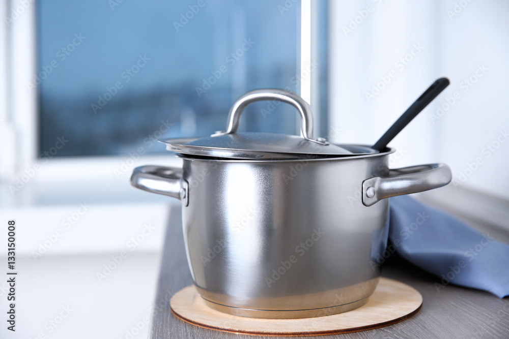 Stainless saucepan on grey kitchen table, closeup Stainless saucepan on grey kitchen table, closeup