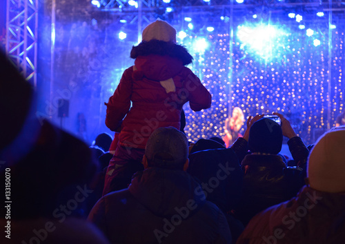 New Year open air celebration in Ukraine. People are viewing a concert on the outdoor performance stage.