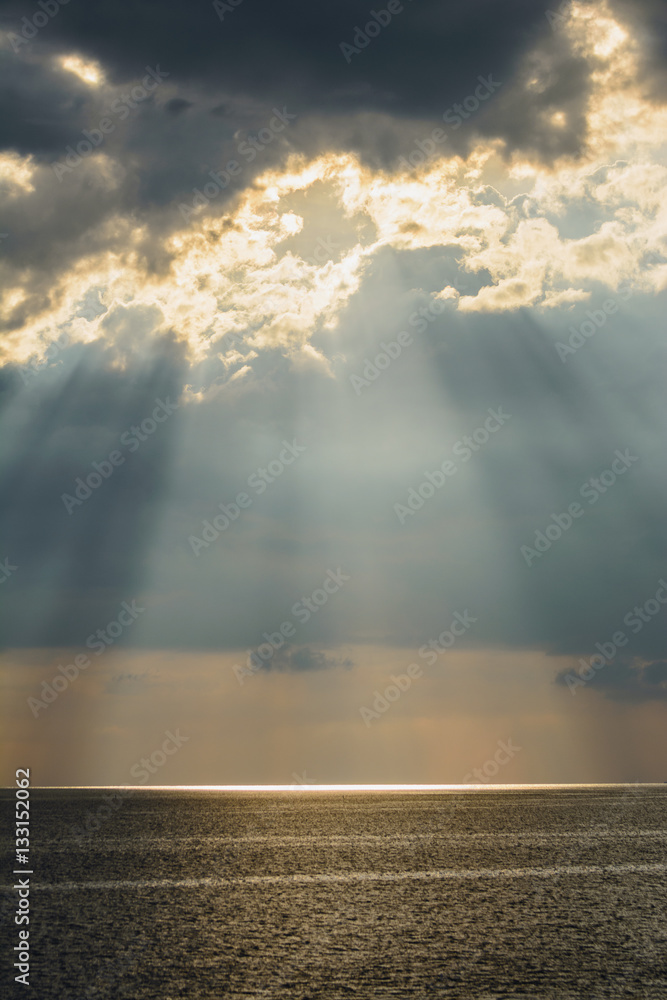 Sun's beam through heavy sky over the sea