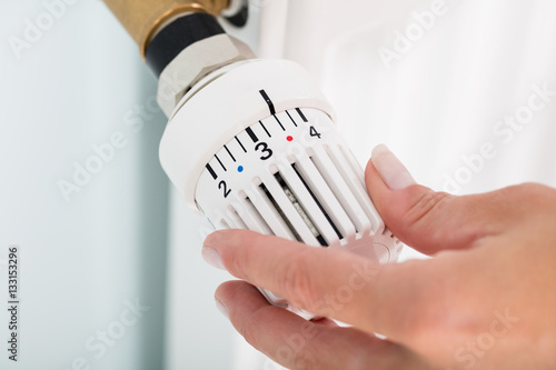 Person Adjusting Thermostat Radiator Valve