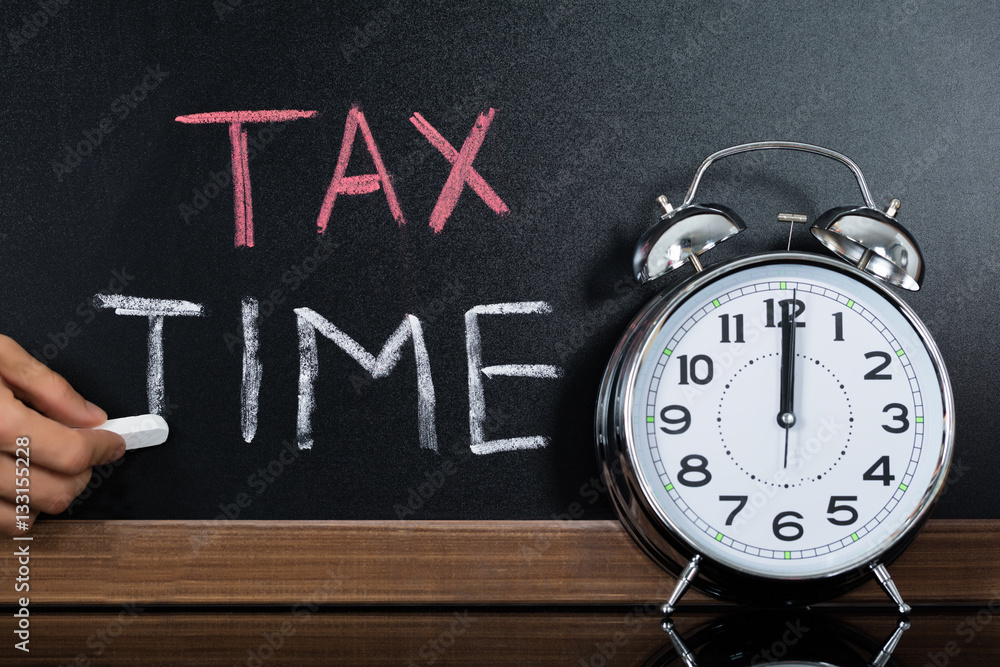 Stopwatch In Front Of Tax And Time Concept On Blackboard Stopwatch In Front Of Tax And Time Concept On Blackboard