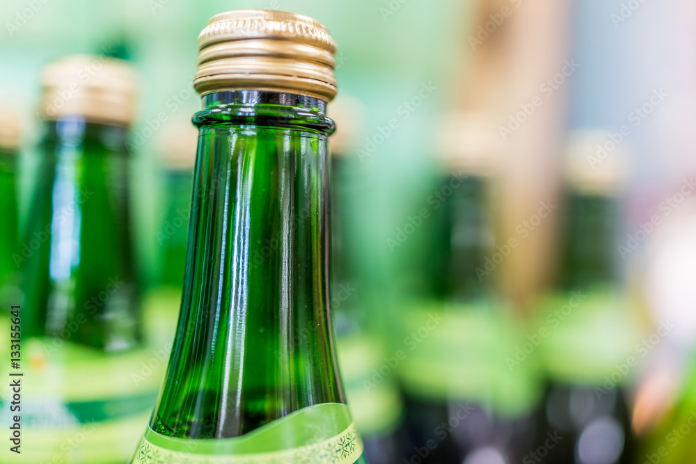 Tops of many green apple glass bottles on display