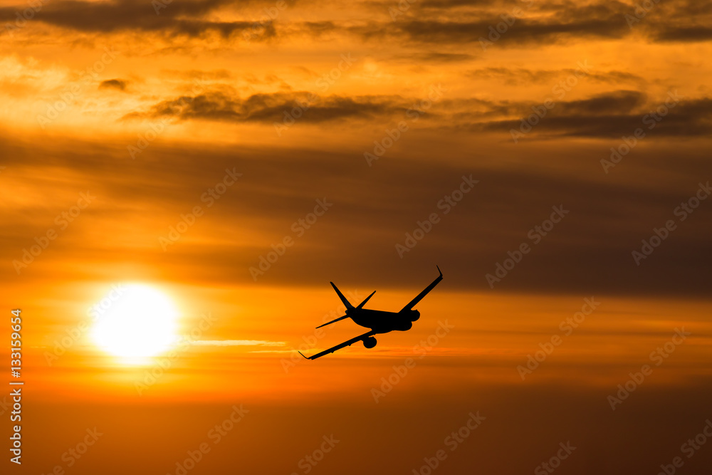 A plane flying towards a beautiful sunset A plane flying towards a beautiful sunset