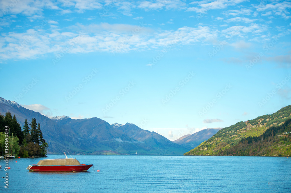 red ship in the lake under the blue sky red ship in the lake under the blue sky
