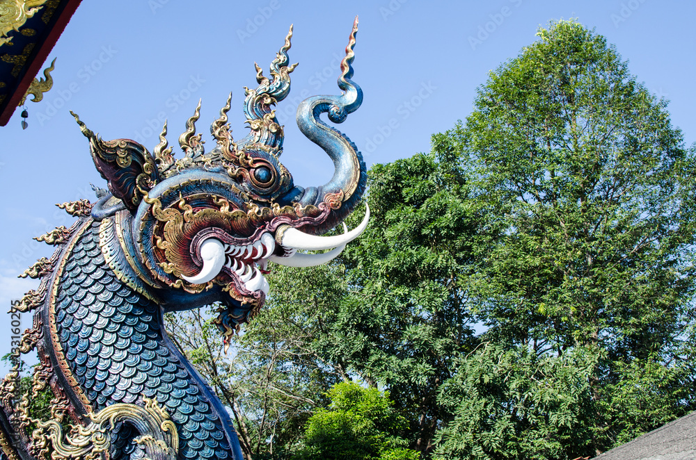 Fototapeta premium Serpent or God of Snake Thai Tradition with Blue Sky at Wat Rong Sua Ten Chiang Rai Thailand. Most Visited from Tourist.