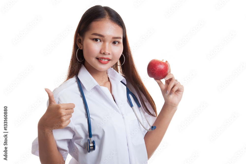 Young Asian female doctor thumbs up with apple. Young Asian female doctor thumbs up with apple.