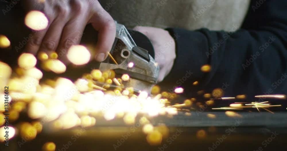 locksmith with a laser cuts in half a sheet of steel causing sparks.The laser heat Nicks iron up to get clean cuts and perfect for buildings with wrought iron.Concept: industry,technology,engineering. locksmith with a laser cuts in half a sheet of steel causing sparks.The laser heat Nicks iron up to get clean cuts and perfect for buildings with wrought iron.Concept: industry,technology,engineering.
