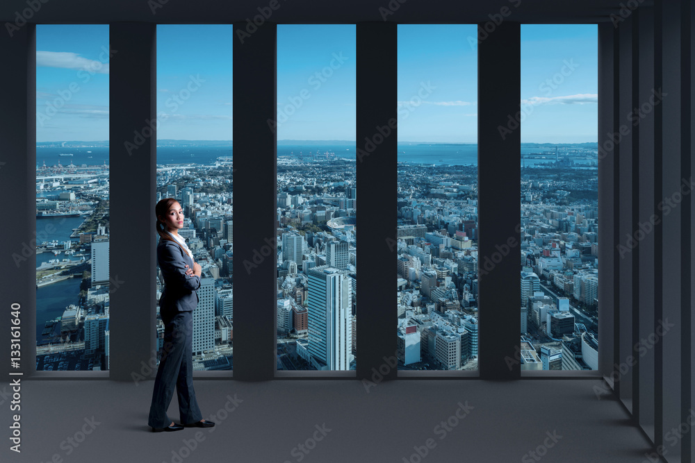 standing young woman and modern city panorama view from inside of building standing young woman and modern city panorama view from inside of building
