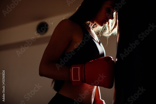 sexy fighter girl in gym with boxing bag
