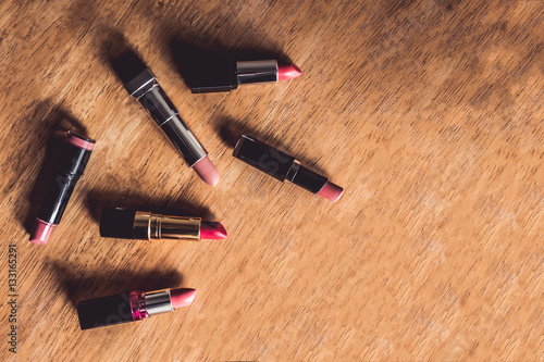 Top view of colorful lipsticks on the wooden table. 