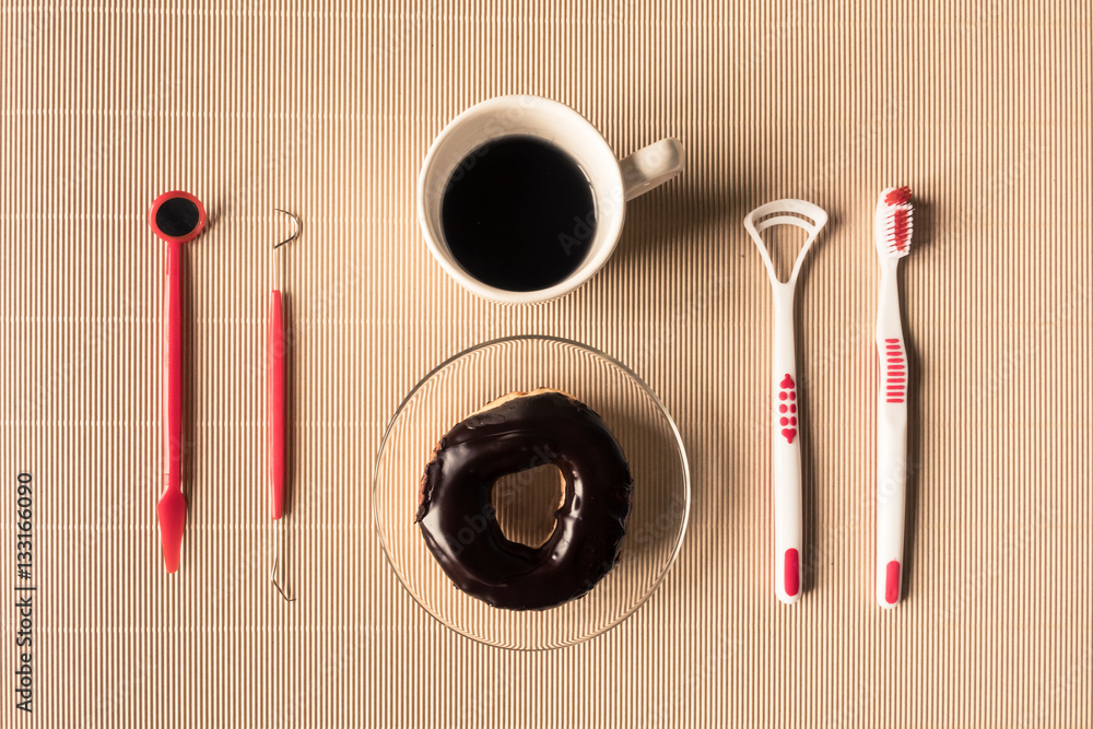 Top view of coffee cup with donut and dental tool equipment on the table Top view of coffee cup with donut and dental tool equipment on the table