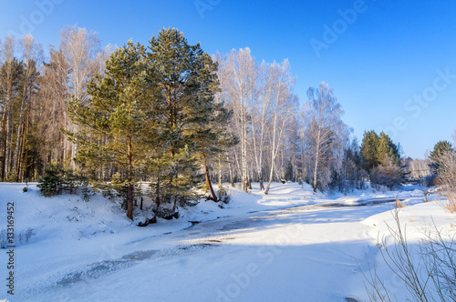 морозное утро в уральском лесу с замерзшей рекой, Россия, февраль