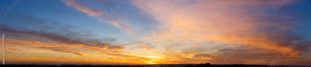 Naklejka premium Piękne niebo zachód słońca z niesamowitymi kolorowymi chmurami na tle błękitnego