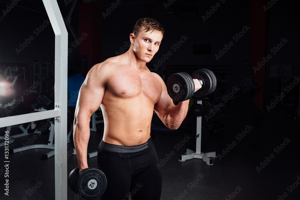 Closeup portrait of professional bodybuilder Strong muscular yang man doing exercise. Workout with barbell at gym. Sports and fitness. Training guy pumping up hands biceps. Closeup portrait of professional bodybuilder Strong muscular yang man doing exercise. Workout with barbell at gym. Sports and fitness. Training guy pumping up hands biceps.