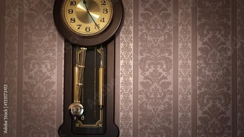 Antique wall clock with a pendulum closeup.