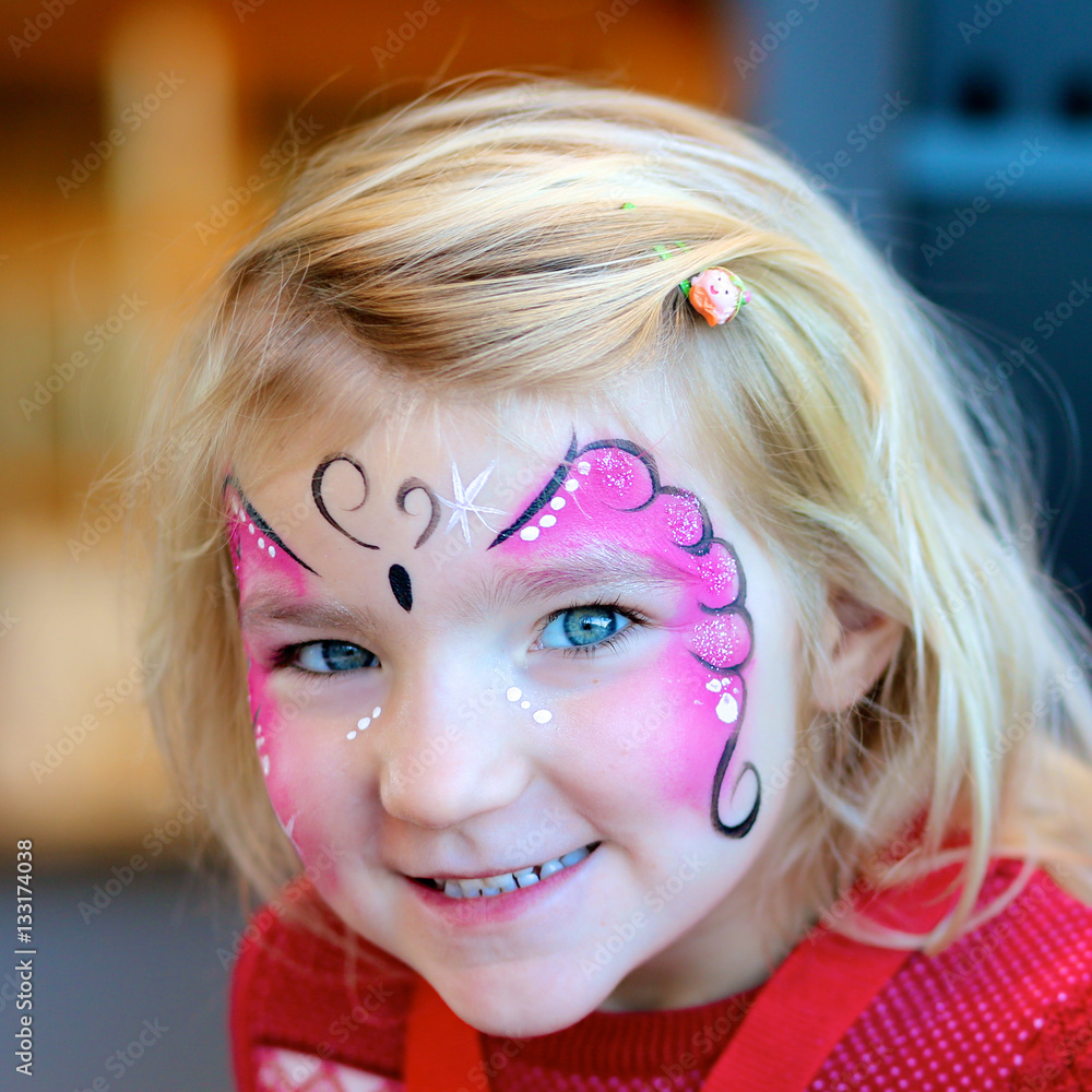 Cute little girl getting her face painted like a butterfly by face ...
