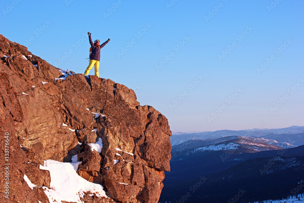 Hiker on top off high rocks. Winter tourism concept.