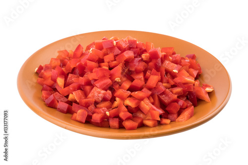 Sliced red pepper in a brown ceramic plate. Isolated on white ba