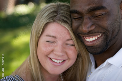 Happy loving multicultural couple hugging and smiling.