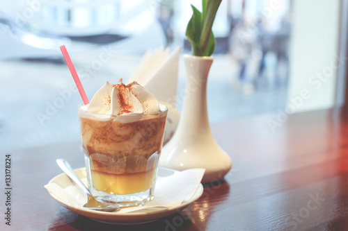 Fotografie Cup of tasty creamy frappuccino in the cafeteria