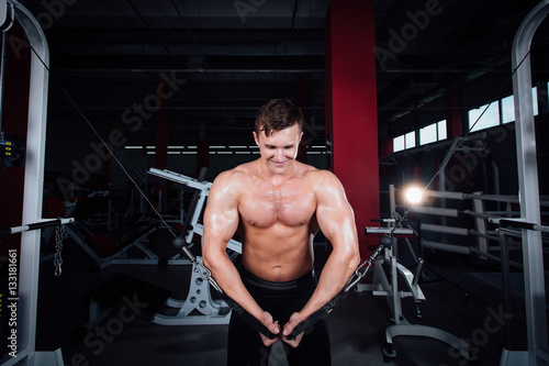 big strong bodybuider without shirts demonstrate crossover exercises. The pectoral muscles and hard training