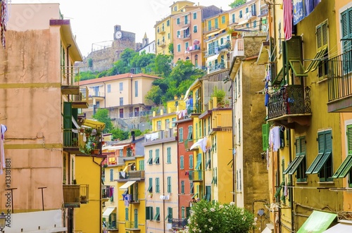 Fototapeta Naklejka Na Ścianę i Meble -  Riomaggiore village, La Spezia, Liguria, northern Italy. Colourful houses on steep hills,castle with clock,laundry on balconies.Part of the Cinque Terre National Park and a UNESCO World Heritage Site.