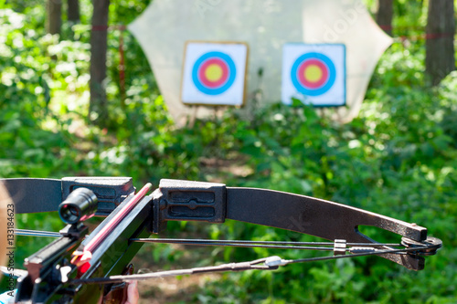 Fotografia Woman aiming crossbow at target