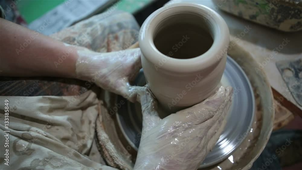 Potter works with clay. Making pots and other products Potter works with clay. Making pots and other products
