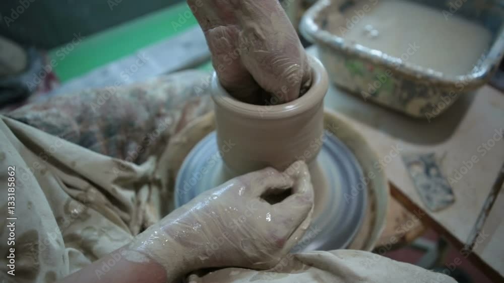 Potter works with clay. Making pots and other products Potter works with clay. Making pots and other products