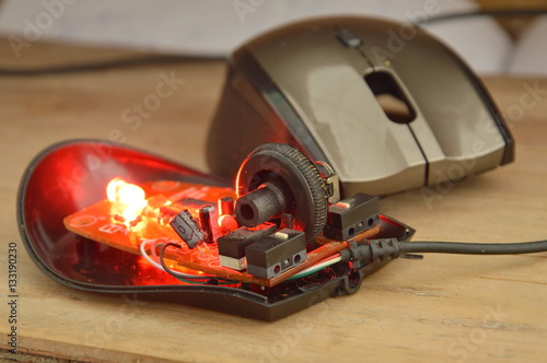 computer mouse separated parts with red light on wooden board