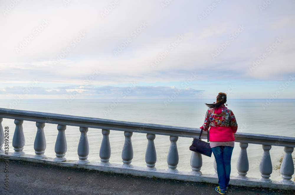 Girl enjoys views of the Black Sea in the botanical garden. Georgia, Batumi.