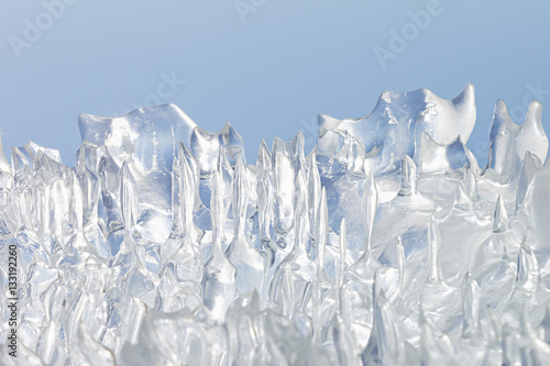 Whimsical surface ice closeup on blue sky background. Copy space. Texture.