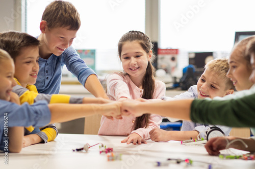 happy children making fist bump at robotics school