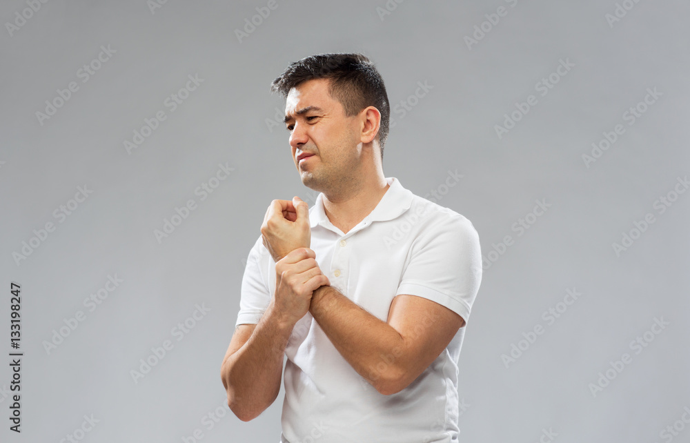 unhappy man suffering from pain in hand unhappy man suffering from pain in hand