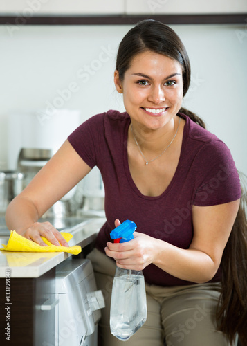 Young cheerful happy housewife with rag