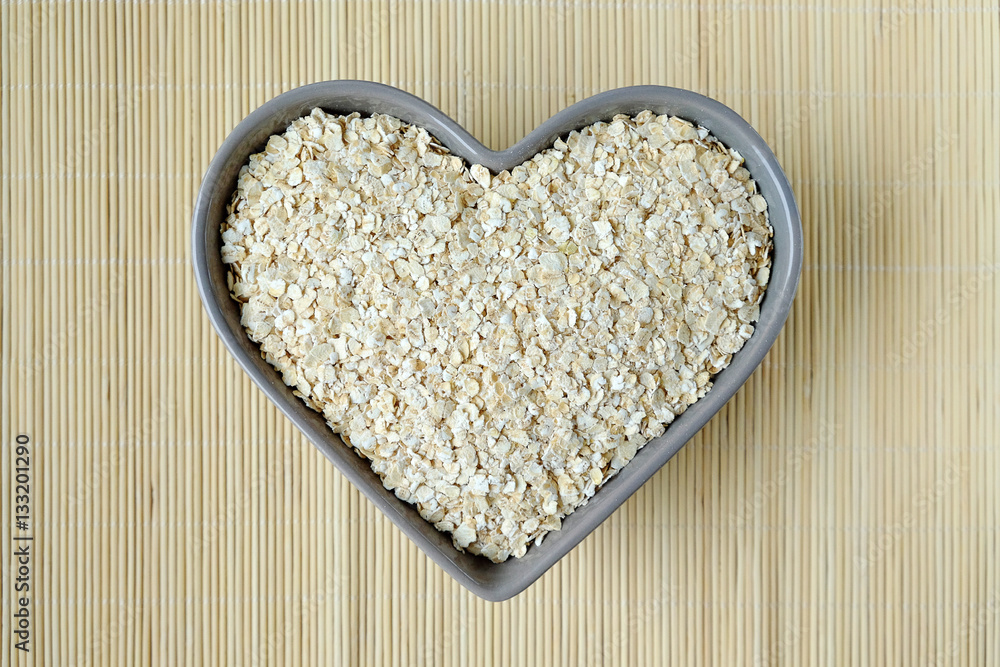 Oat flakes in a bowl in the shape of heart Oat flakes in a bowl in the shape of heart